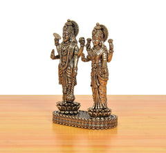 Brass Lakshmi and Vishnu idol, side angle showing crowns and raised arm poses