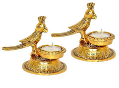 Gold-tone bird diya lamp pair with round candle cups and engraved pedestal bases