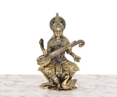Brass Maa Saraswati idol seated on lotus with veena, detailed jewelry
