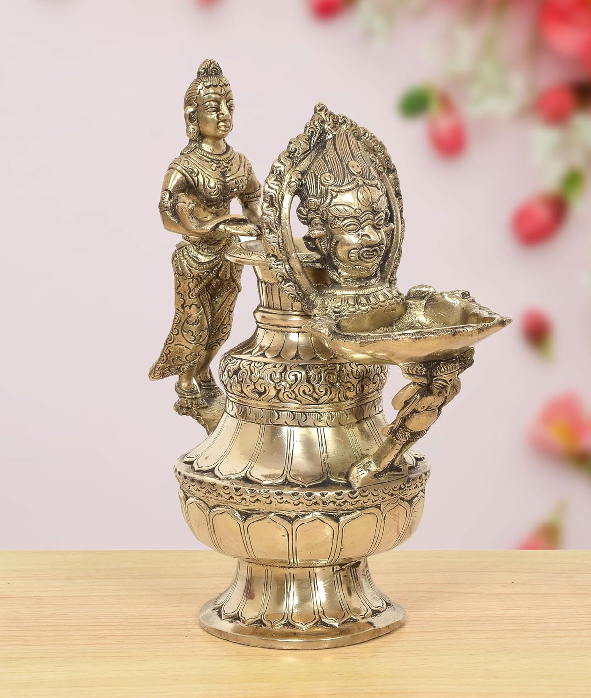 Brass oil lamp with two deity figures and ornate flame bowl