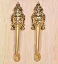 Golden brass door handle pair with smiling face head motifs on the plates
