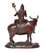 Close-up of Shiva seated on Nandi statue, detailed trident and patterned robe saddle