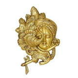 Close-up brass Krishna mask wall hanging with detailed crown and serene face
