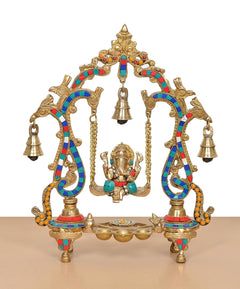 Brass Ganesha playing on swing idol front view with gold-tone frame and bells