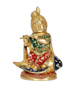 Krishna brass idol seated, green red blue robe accents, holds flute, side view