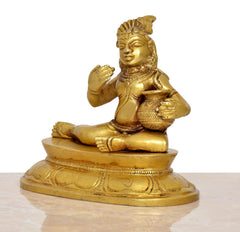 Brass Krishna Laado Gopal statue from side, seated with laddu in lap