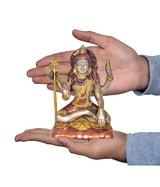 Brass Shiva statue held in hands, seated with trident, showing sculpted details