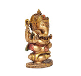 Ganesha resin idol seated posture, gold tone with red and green accents, shankh-themed decorative hands