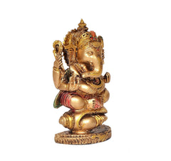 Ganesha resin idol seated posture, gold tone with red and green accents, shankh-themed decorative hands