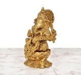 Golden brass Ganesha seated on lotus, side view with raised hand