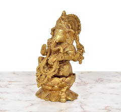 Golden brass Ganesha seated on lotus, side view with raised hand