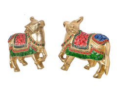Brass cow pair wall hanging, angled view showing faces, horns and decorated chest panels