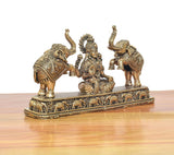 Close view of seated Lakshmi figurine between elephants with intricate base decoration.