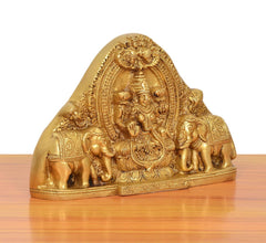 Gold brass Gaja Lakshmi idol with elephants, angled front, ornate relief details