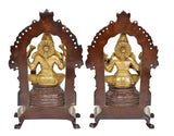 Lakshmi and Ganesha standing idols on dark bases with decorative arched frames