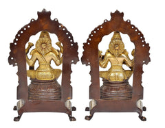Lakshmi and Ganesha standing idols on dark bases with decorative arched frames