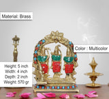 Multicolor brass Darbar idol with gemstone-like dots and three figures under arch