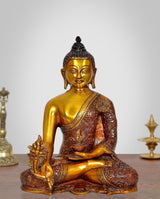 Gold Buddha statue in meditating pose, brown patterned robe, seated on an ornate base