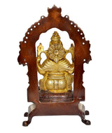 Front view Brass Ganesha idol inside carved arch, seated on ornate pedestal