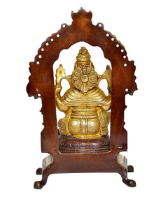 Front view Brass Ganesha idol inside carved arch, seated on ornate pedestal