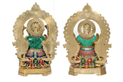 Back view of brass Lakshmi and Ganesh idols with detailed halo arches and colorful clothing