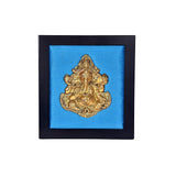 Brass Ganesha centerpiece on blue inset inside dark wooden frame