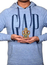 Small brass Ganesha statue held in hands, colorful blue and red enamel