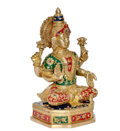 Brass Lakshmi idol angled view, seated with gold crown and red-green painted attire
