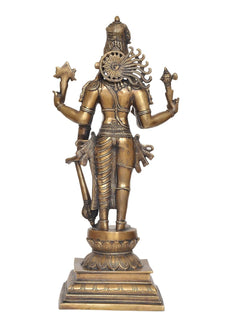 Brass Hari-Hara deity statue back/side view showing headdress and raised weapon hands