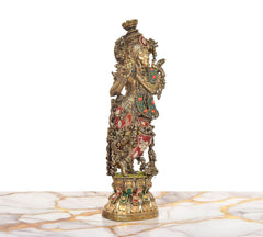 Lord Krishna brass statue playing flute, rear three-quarter view, ornate filigree details.