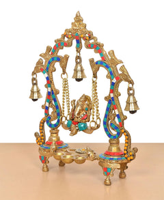 Brass Ganesha swing idol in 3/4 view, multicolor accents on curved pillars and bells