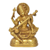 Golden Saraswati idol with veena across lap and raised blessing hand, brass finish