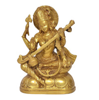 Golden Saraswati idol with veena across lap and raised blessing hand, brass finish