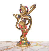Krishna brass statue playing flute with coiled serpent hood, colorful red blue jewelry design.