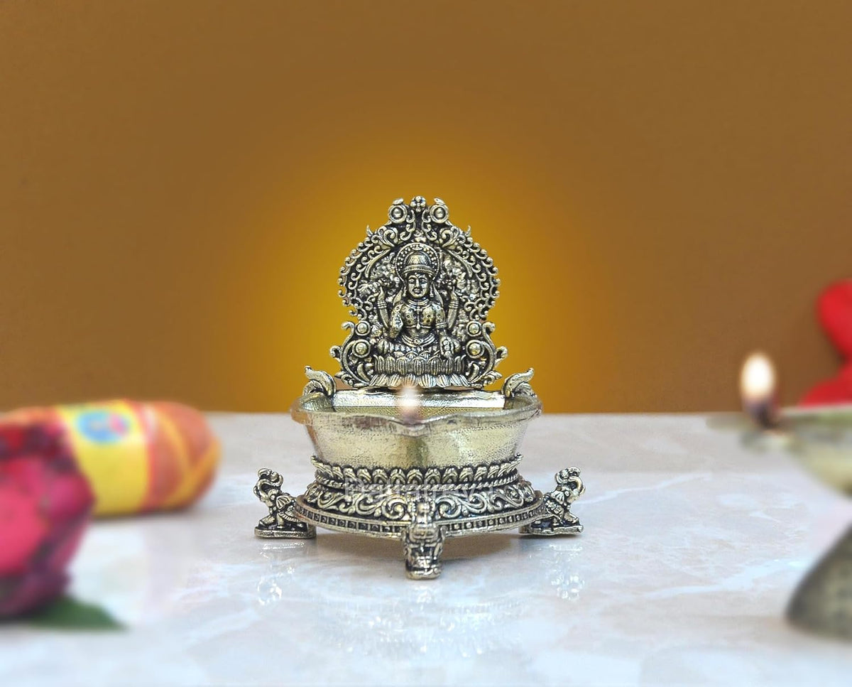 Brass Lakshmi oil lamp diya with ornate openwork crown and base, front view