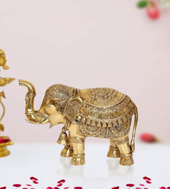 Brass elephant figurine with trunk raised, ornate etched patterns across body