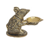 Brass mouse diya lamp, side view with wick flame and shallow oil bowl