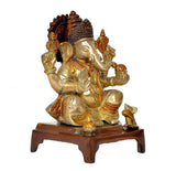 Brass Ganesha statue from angled side, dark red crown, gold-toned body