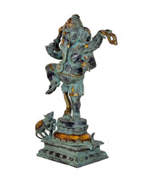 Side view of dancing Ganesha statue with turquoise body and gold accents, ornate base