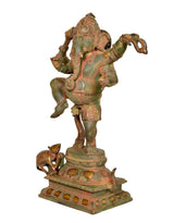 Side view of dancing Ganesha statue with decorative platform and small figure at base