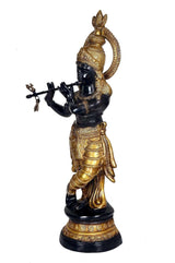 Krishna bronce dorado de pie en perfil, corona y tridente pequeño; figura azul oscuro