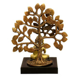 Brass Buddha idol under tree with detailed foliage, black square base