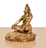 Seated Lord Shiva resin sculpture from side view, one hand resting and green cloth across chest.