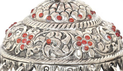 Close-up of silver carved chatta with red bead inlays and ornate engravings