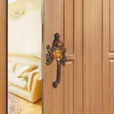 Brass Buddha face door handle on a wooden door panel