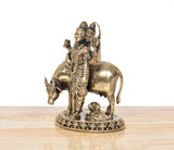 Bronze deity statue with detailed robe and headdress, standing on bull
