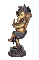 Close-up brass Ganesha idol face and trunk, dark beaded skirt, ornate headpiece