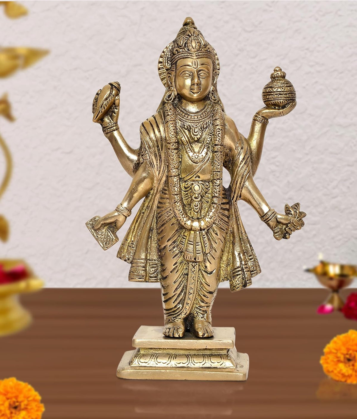 Brass Dhanvantri statue with four raised arms, gold-tone detailing, on pedestal base.