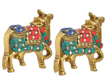 Brass cow pair figurines, close view of faces and jewel-like saddle details