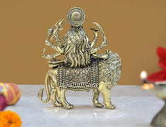 Back view of brass Durga Maa statue on lion, layered dress and crown detailing